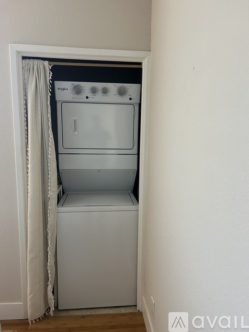 A white dryer is in a small alcove.