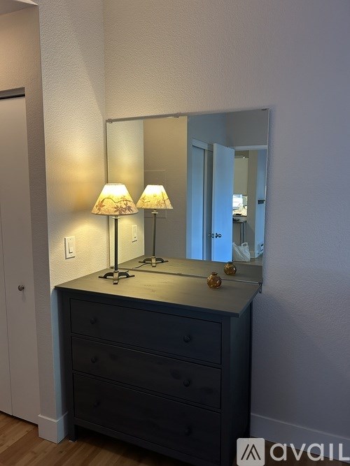 A dresser with a mirror and two lamps on it.