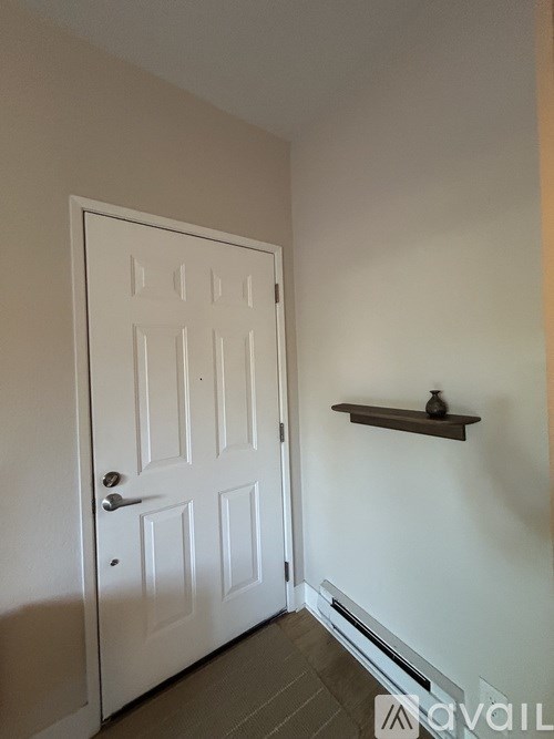 A white door with a shelf above it.