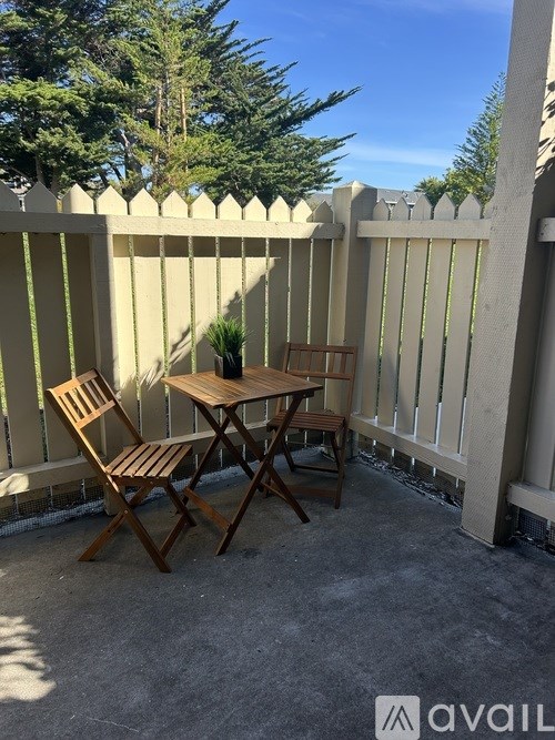 A small table and two chairs are on a patio.