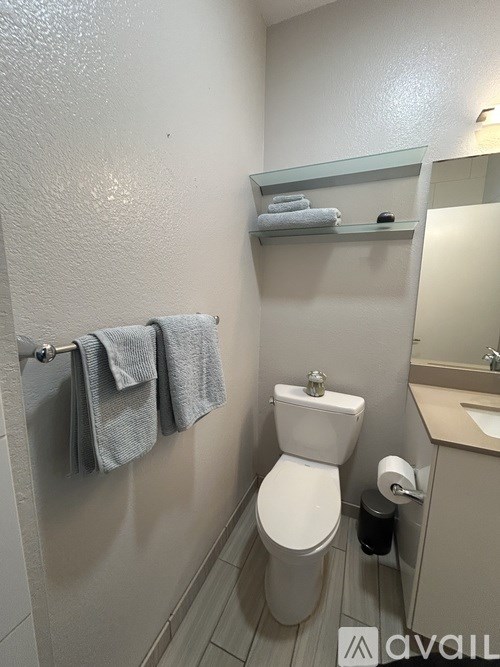 A white toilet with a towel hanging on the towel rack.
