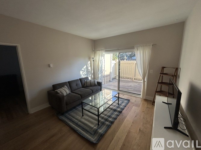 A living room with a grey sofa and a glass coffee table.