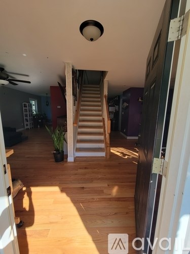 A wooden staircase leads to a second floor in a house.