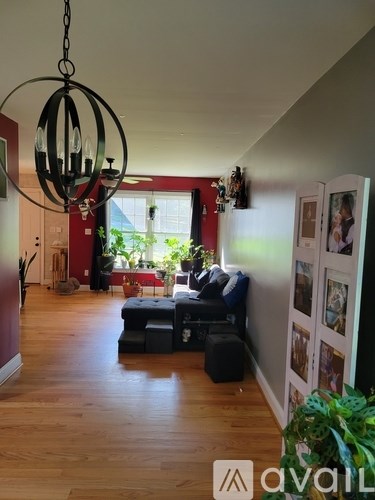A living room with a blue couch and a chandelier.