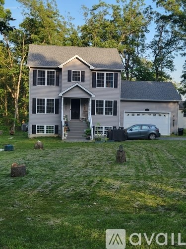 A house with a grey roof and a car parked in front.