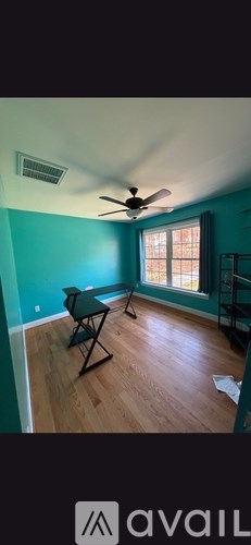 A room with a ceiling fan and a table.