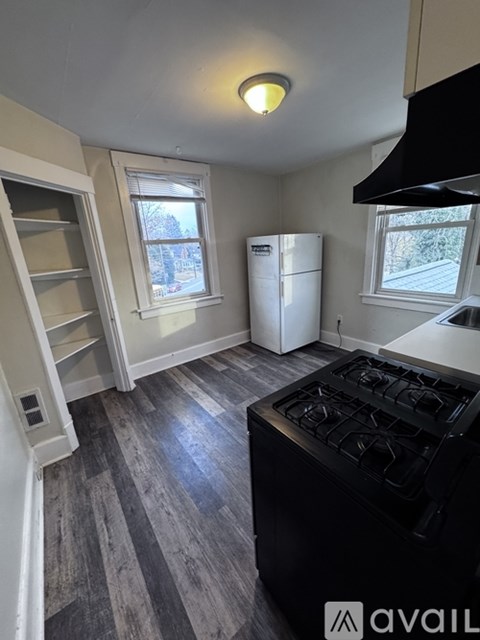 A kitchen with a black stove top oven and a white refrigerator.