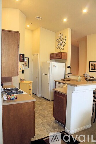 A kitchen with a white refrigerator and wooden cabinets.