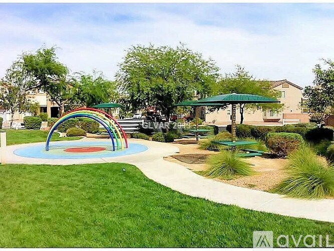 A playground with a rainbow-colored arch and a blue circle in the middle.