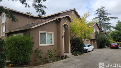 A house with a brown exterior and a car parked in front.