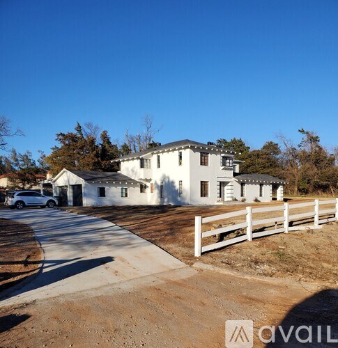 A white house with a white fence in front of it.