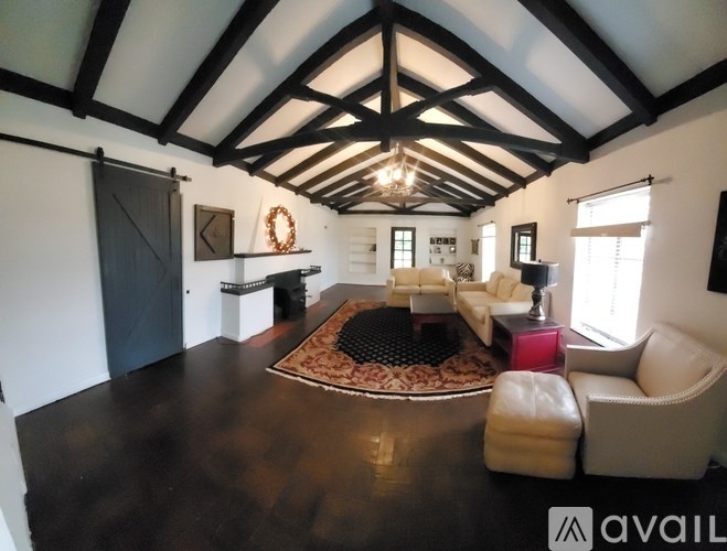 A living room with a black and white color scheme and a large rug on the floor.