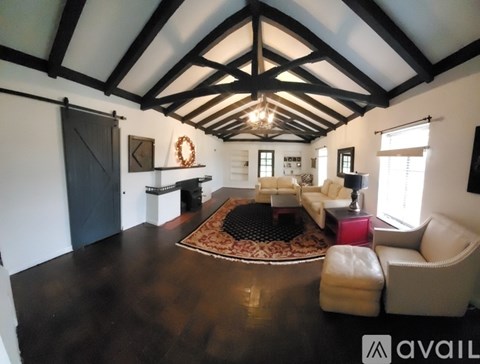 A living room with a black and white color scheme and a large rug on the floor.