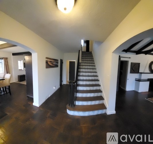 A staircase with a metal railing and a wooden handrail.