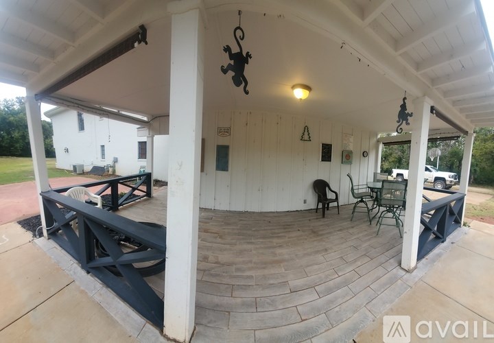 A covered patio area with a table and chairs.