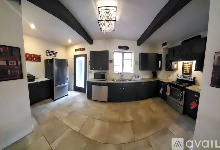 A kitchen with black cabinets and a large island.