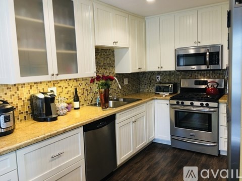A kitchen with white cabinets and a tiled backsplash.