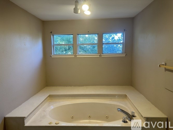 A bathroom with a tub and a window.