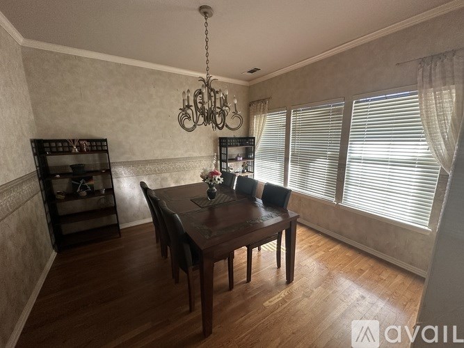 A dining room with a wooden table and chairs.