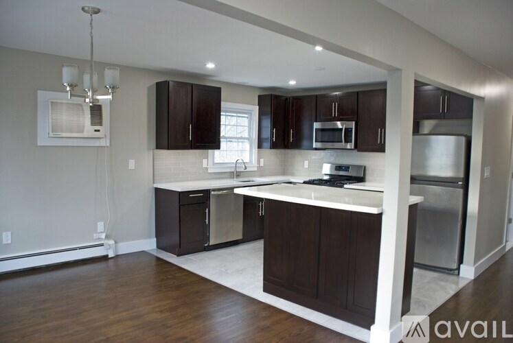 A kitchen with dark brown cabinets and a white island.