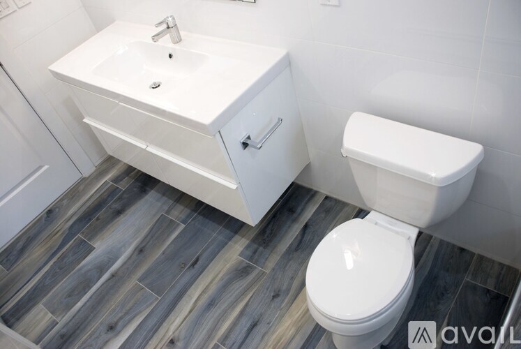 A white toilet sits next to a white sink in a bathroom.