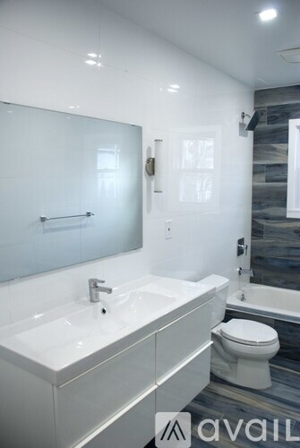 A bathroom with a white sink and toilet.