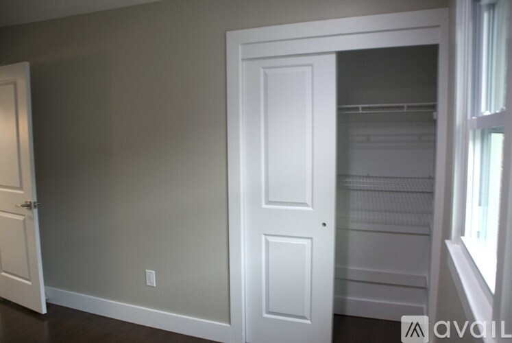 A white door is in a room with a grey wall.