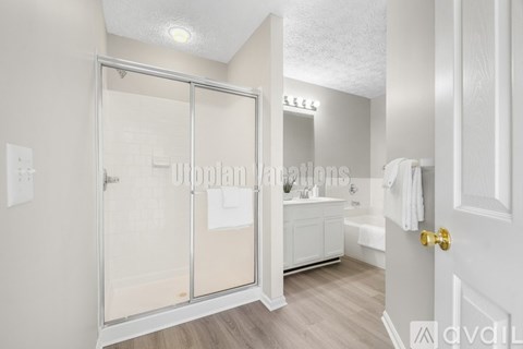 A bathroom with a glass shower door and a white cabinet.
