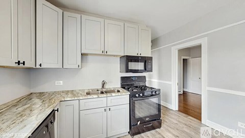 A kitchen with a black stove top oven and a marble counter top.