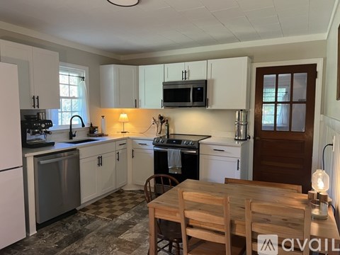 A kitchen with white cabinets and a black stove top oven.