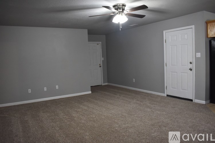 A room with a ceiling fan and two doors.