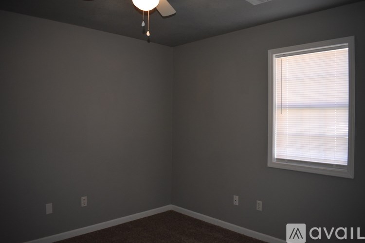 A room with a window and a fan on the ceiling.