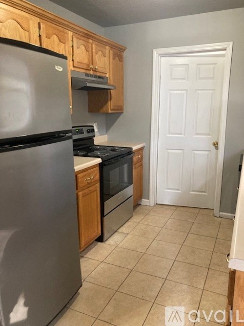 A kitchen with a refrigerator, oven, and stove.