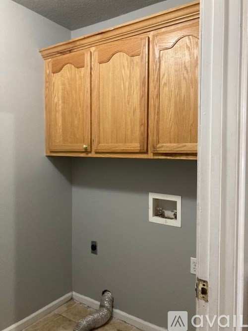 A wooden cabinet is mounted on a wall.