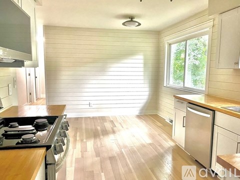 A kitchen with wooden floors and white walls.