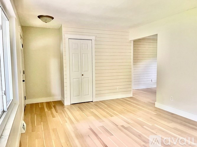 A room with wooden flooring and a white door.