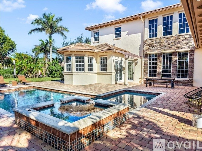 A house with a pool in front of it.