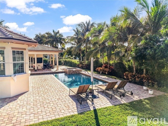 A house with a pool and a patio with chairs.