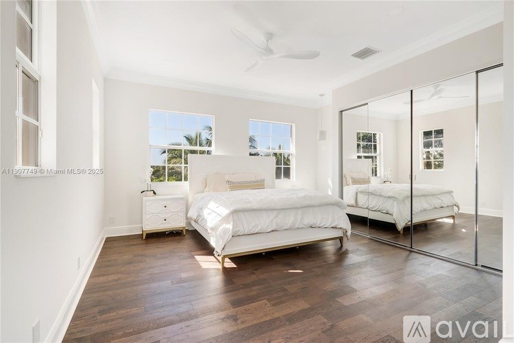 A bedroom with a large bed and a mirror on the wall.