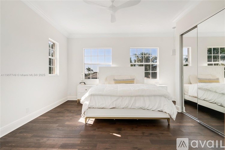 A bedroom with a large bed and a mirror on the wall.