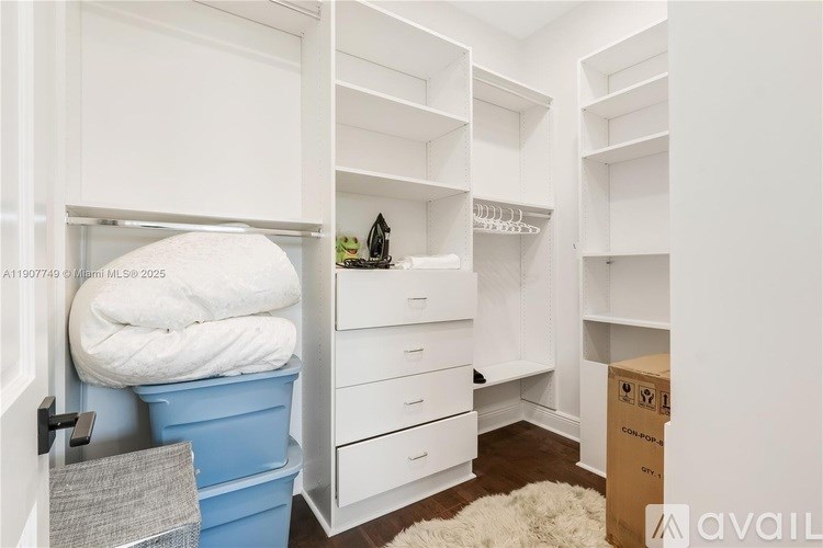 A white closet with a white towel hanging on the door.