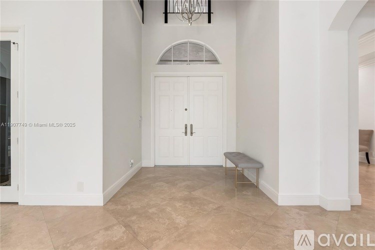 A room with a white door and a bench in front of it.