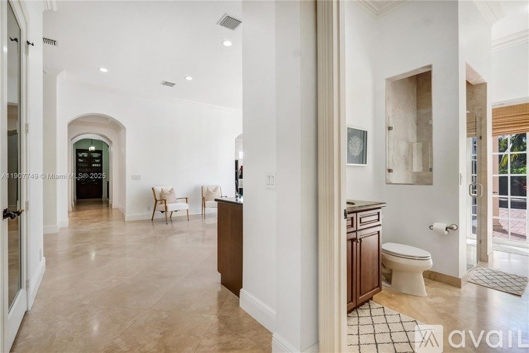 A spacious bathroom with a toilet, sink, and mirror.