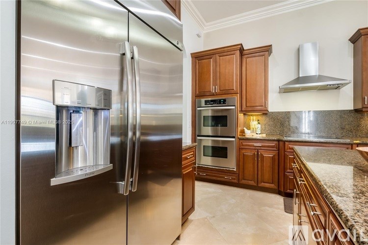 A modern kitchen with a stainless steel refrigerator and wooden cabinets.