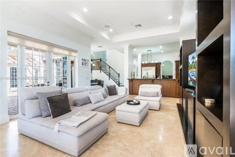 A spacious living room with a grey sofa and a white ottoman.