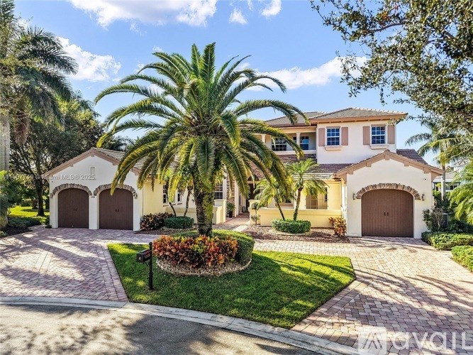 A house with a driveway and a palm tree in front.