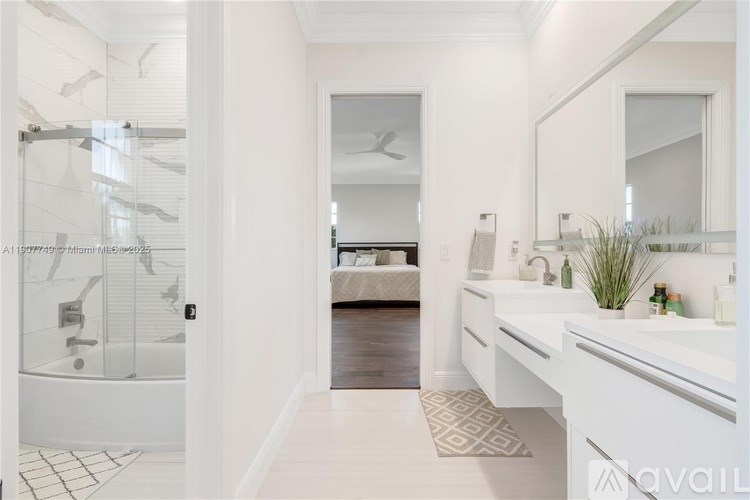 A bathroom with a white tub, sink, and mirror.