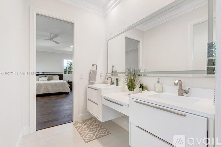 A white bathroom with a vanity and a mirror.