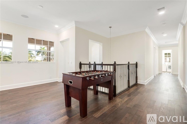 A room with a pool table and a railing.