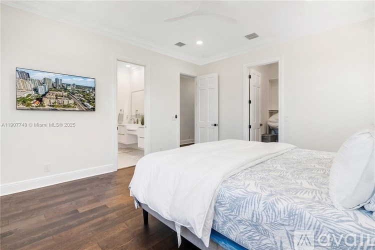 A bedroom with a large bed and a painting of a cityscape on the wall.
